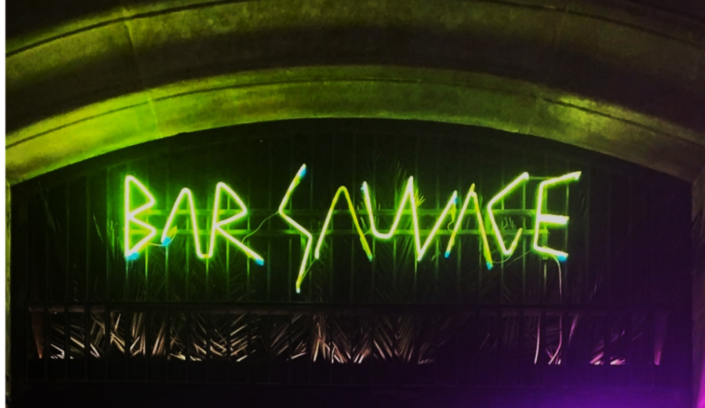 Neon sign that reads Bar Sauvage. The entrance to one of the best bars to visit in El Born.