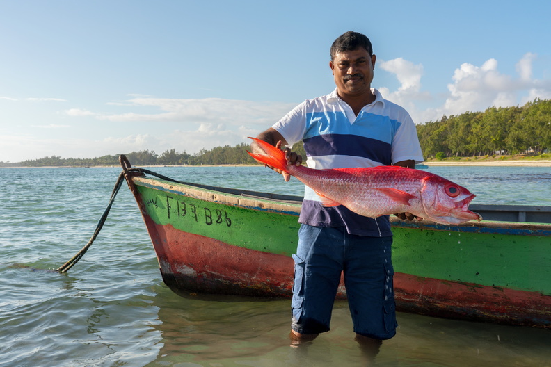 A local fisherman holds up a fish.